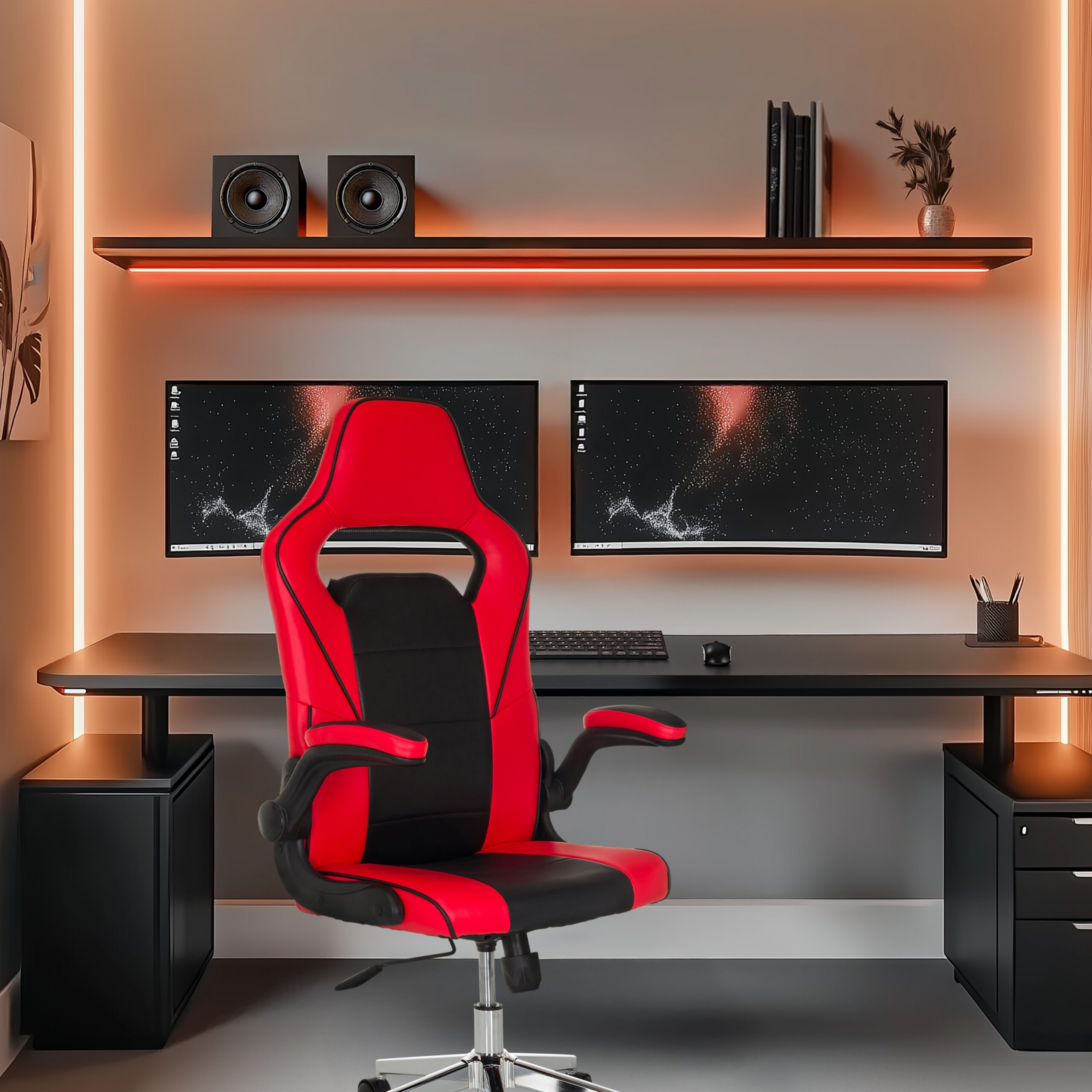 Ein rot-schwarzer Gaming-Stuhl vor einem Schreibtisch mit zwei Monitoren, Tastatur und Lautsprechern.