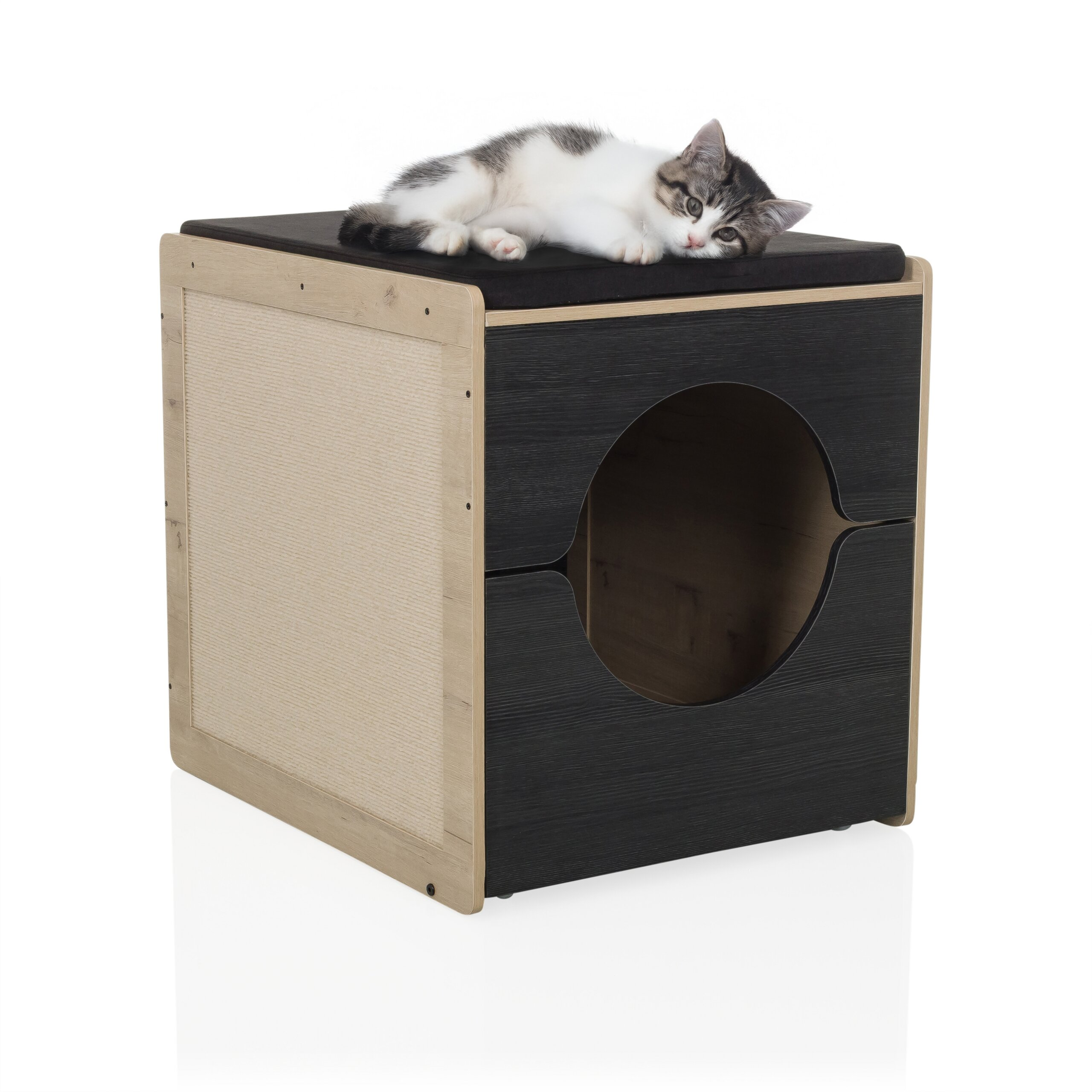 Eine schwarz-weiße Katze liegt auf einem schwarzen und hölzernen Katzenhaus mit Kissen auf weißem Hintergrund.