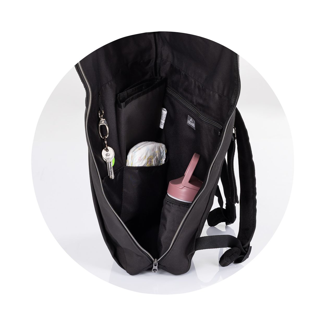 Offener schwarzer Rucksack mit Fächern, Schlüsseln, Windel und rosa Trinkflasche.