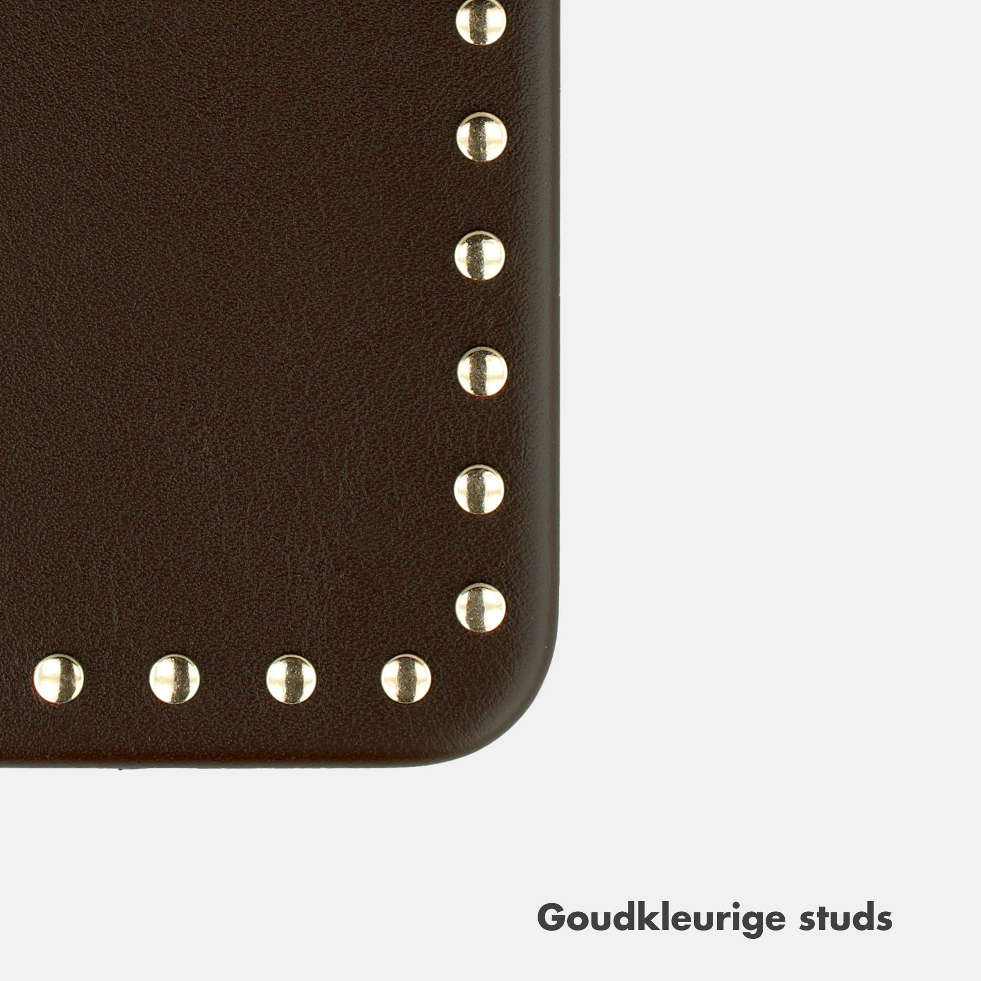 Brown leather with gold studs along the corner on a light background.