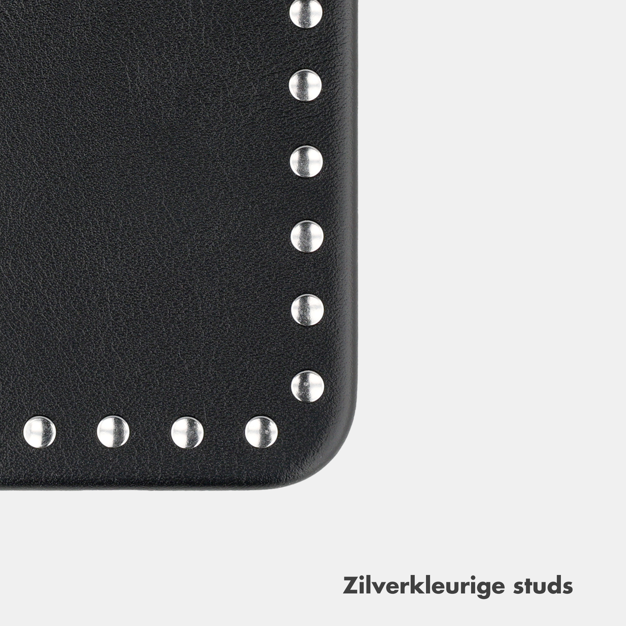 Close-up of a black leather surface with silver studs along the curved edge against a light background.