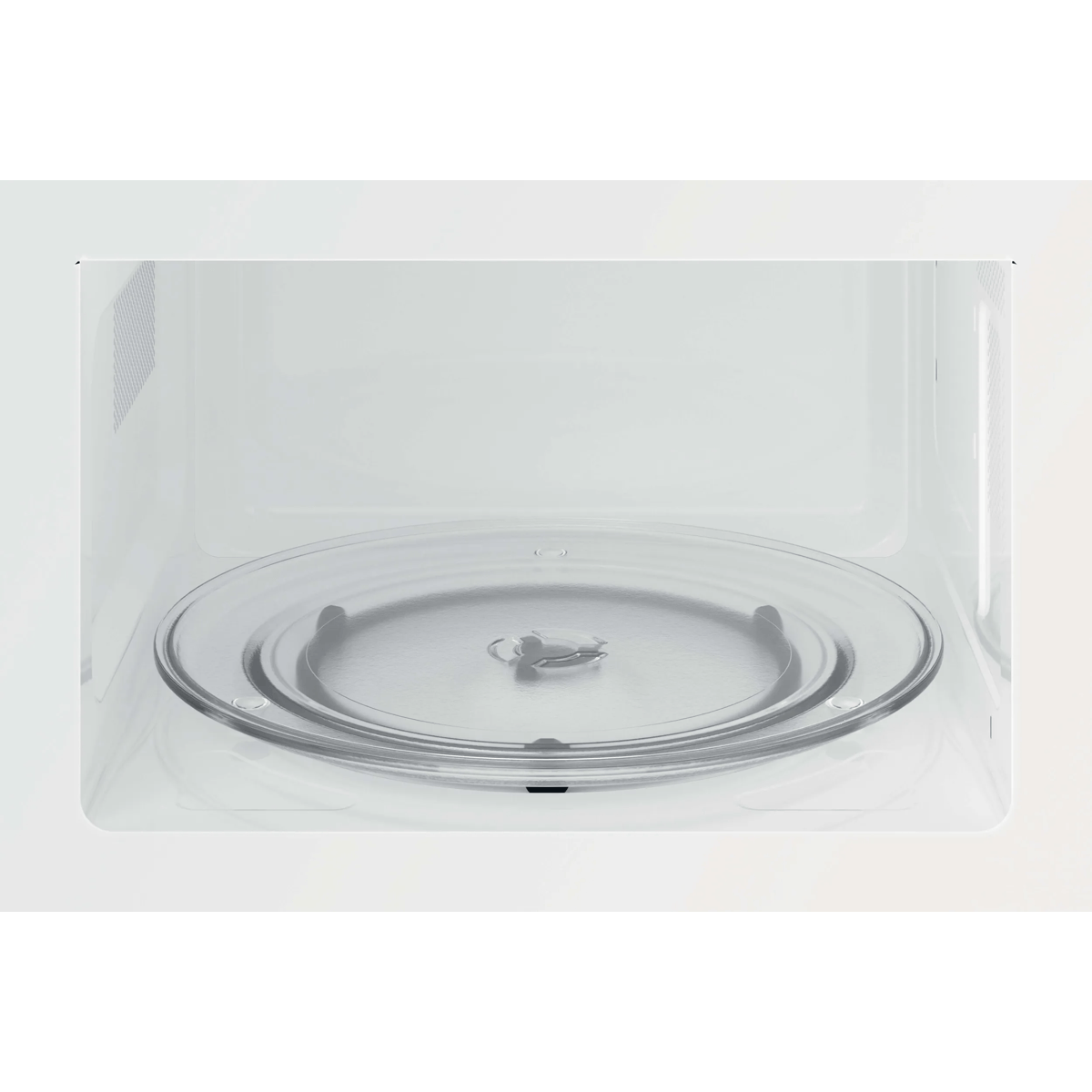 El interior de un microondas blanco y limpio con un plato giratorio de vidrio.
