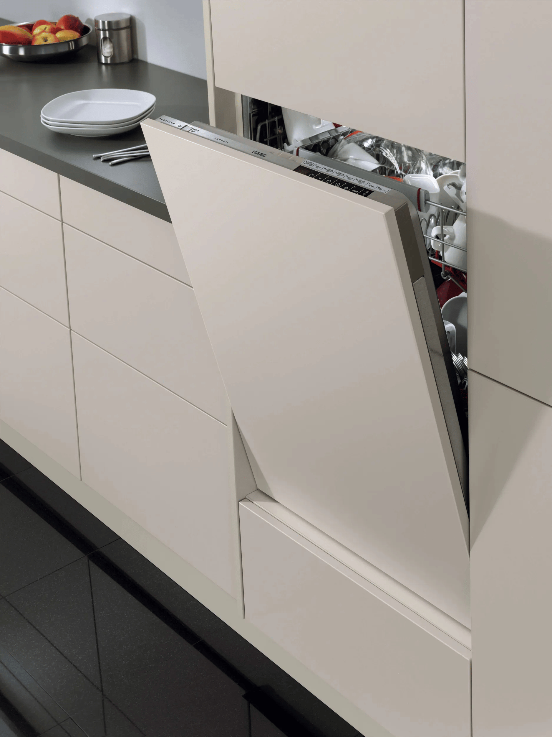 Una lavastoviglie integrata beige è a metà aperta in una cucina moderna.
