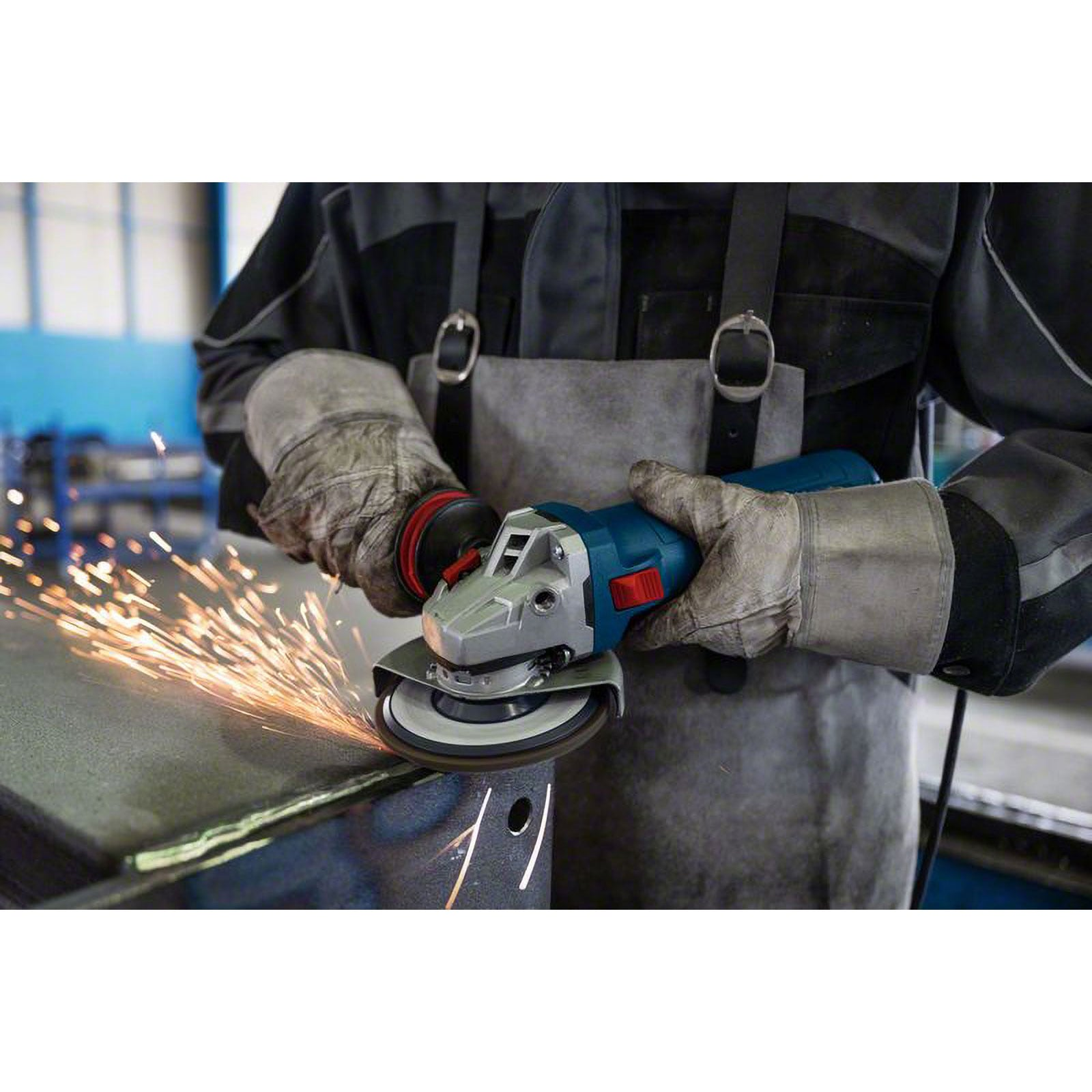 Ein Arbeiter mit Schutzkleidung schneidet Metall mit einem Winkelschleifer, wodurch hell glühende Funken entstehen.