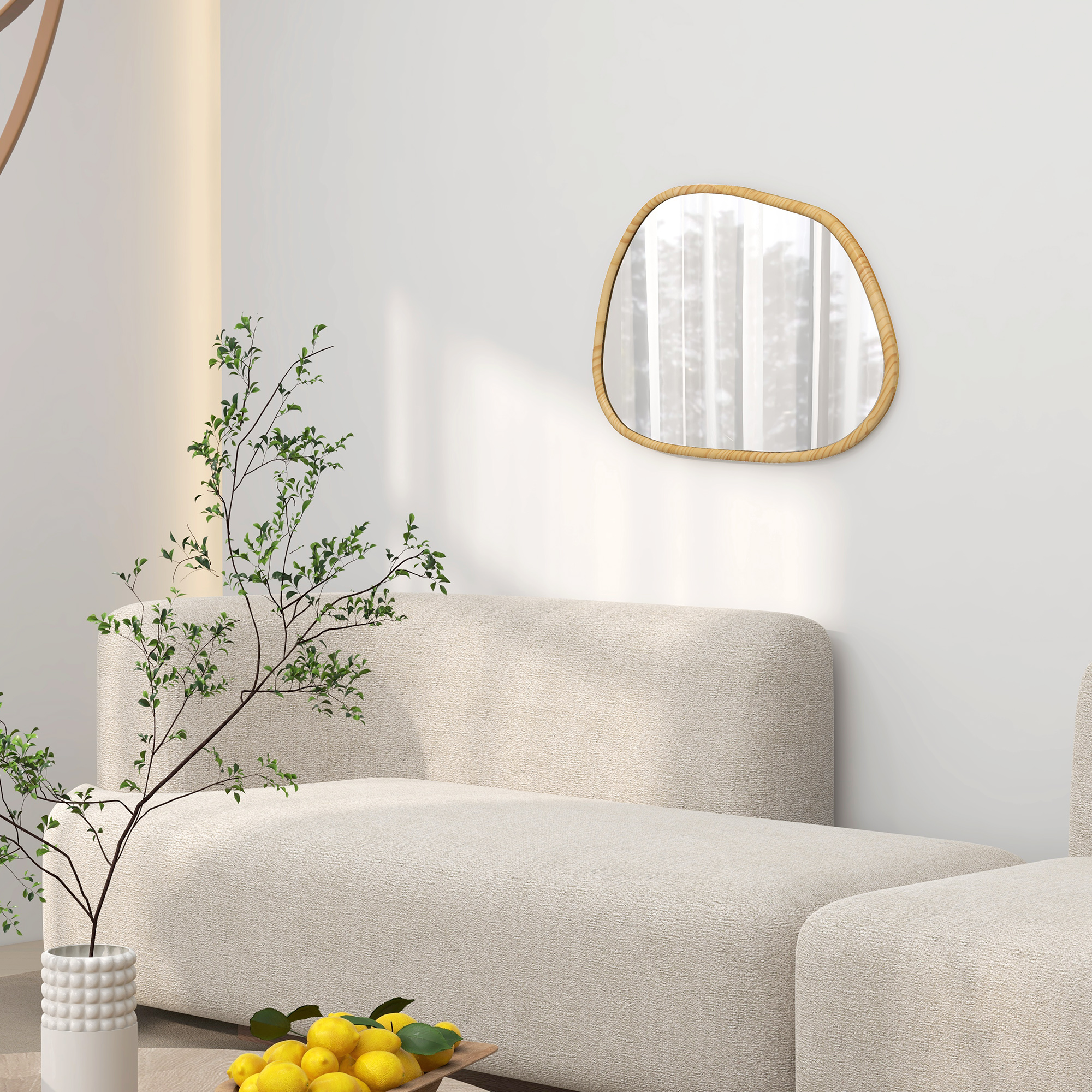 Sofá beige, espejo de madera irregular en la pared, planta y bol con limones en primer plano.