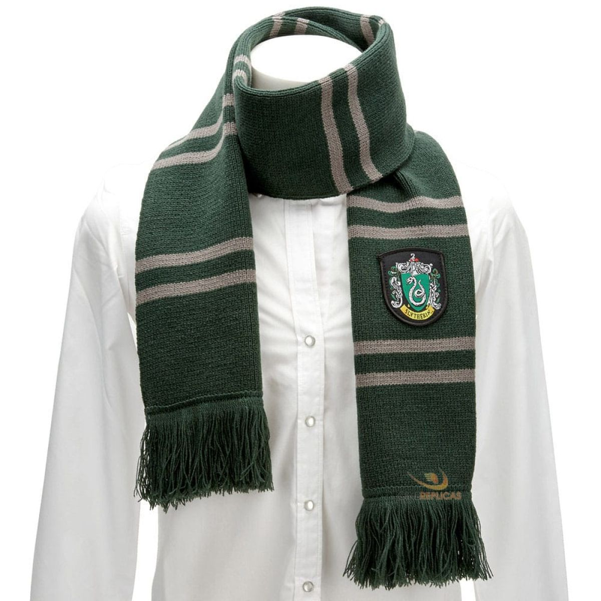 Sciarpa di Serpeverde a righe verdi e grigie con frange e stemma su camicia bianca.