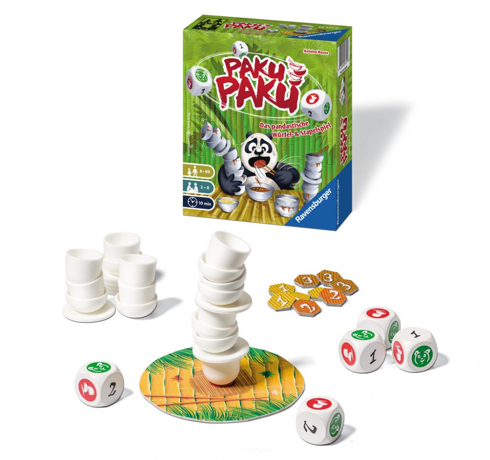 Ravensburger Brettspiel Paku Paku mit Schachtel, gestapelten weißen Schüsseln, Spielsteinen und Würfeln auf weißem Hintergrund.