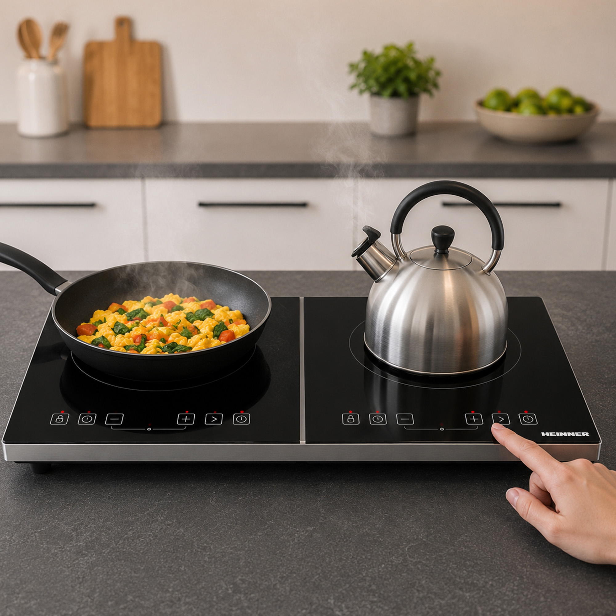 Een hand drukt op een knop van een inductiekookplaat met pan en fluitketel.