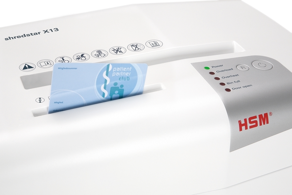 Biała niszczarka dokumentów HSM Shredstar X13 wciągająca niebieską plastikową kartę.
