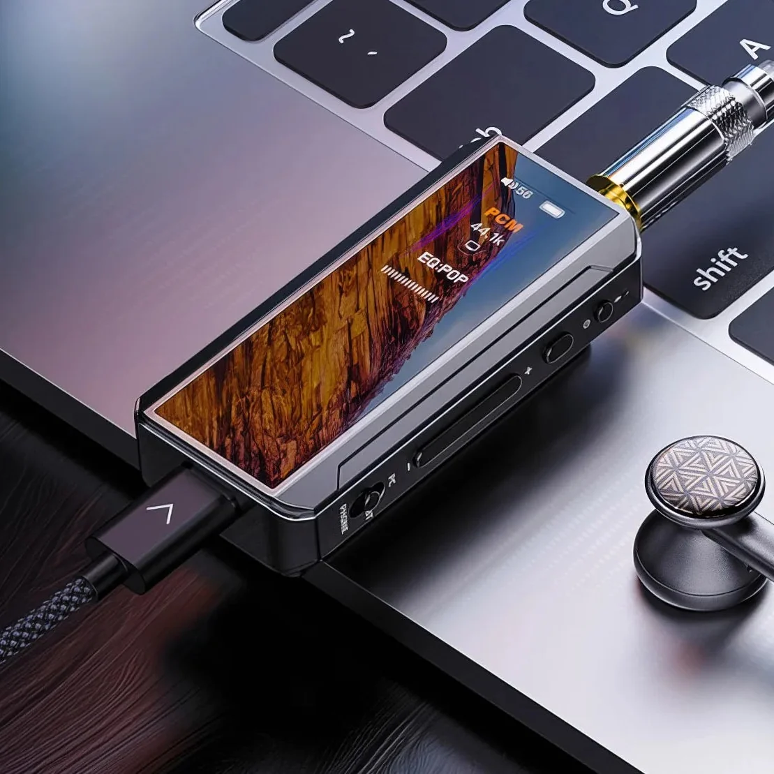 Przenośny wzmacniacz audio wysokiej rozdzielczości z wyświetlaczem, podłączony do laptopa.