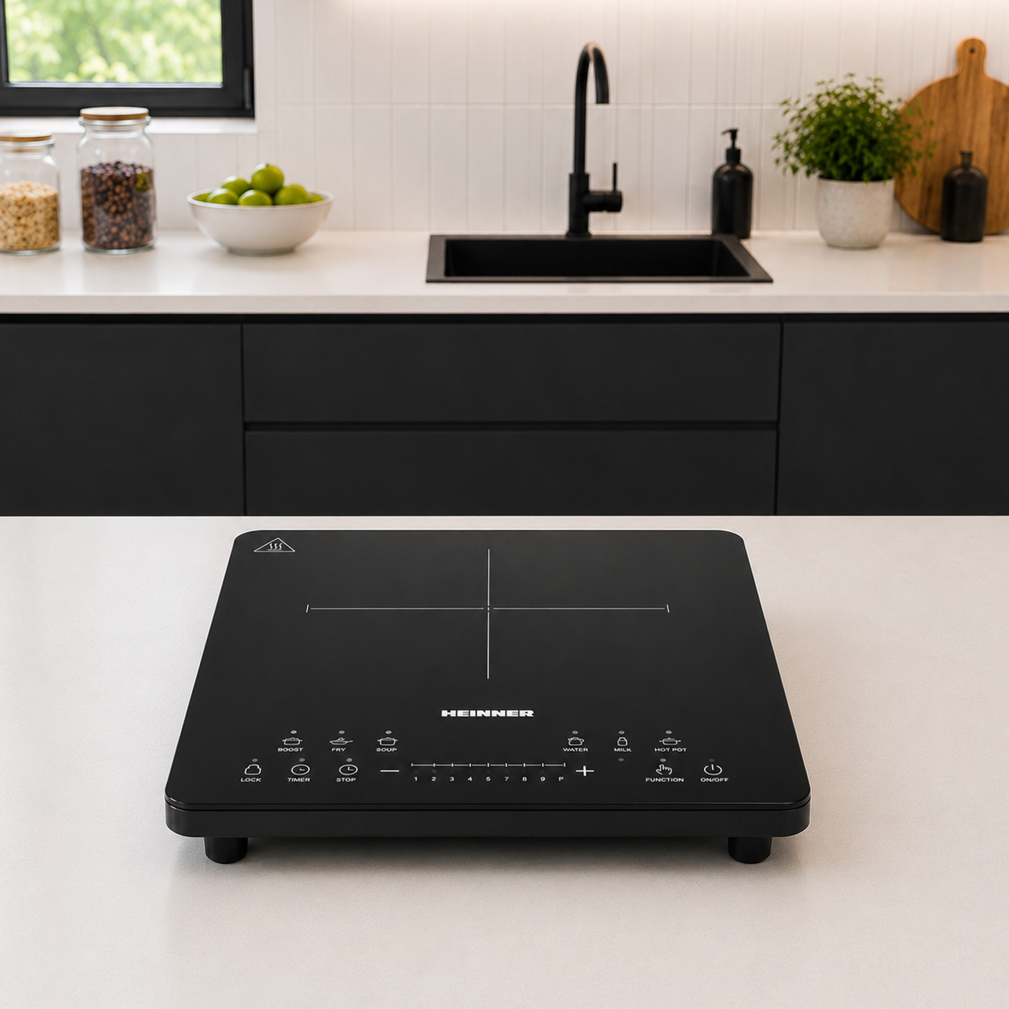 A black induction cooktop sits on a white countertop in a modern kitchen featuring a black sink and white cabinets.
