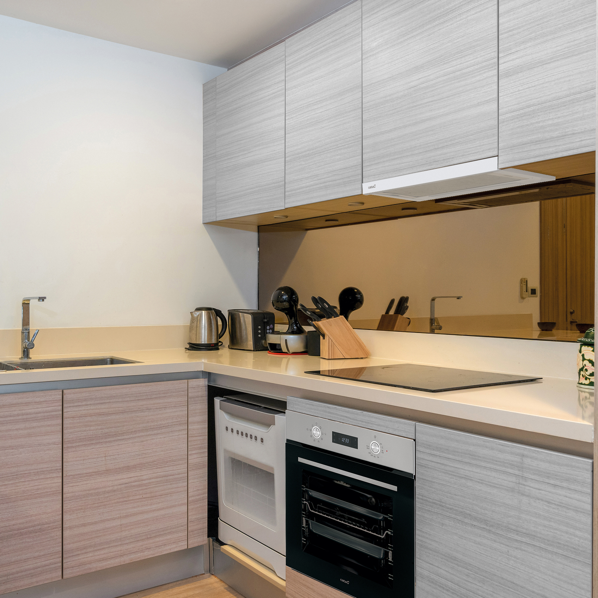 Cocina moderna con gabinetes de madera clara, electrodomésticos negros, fregadero y placa sobre encimera.