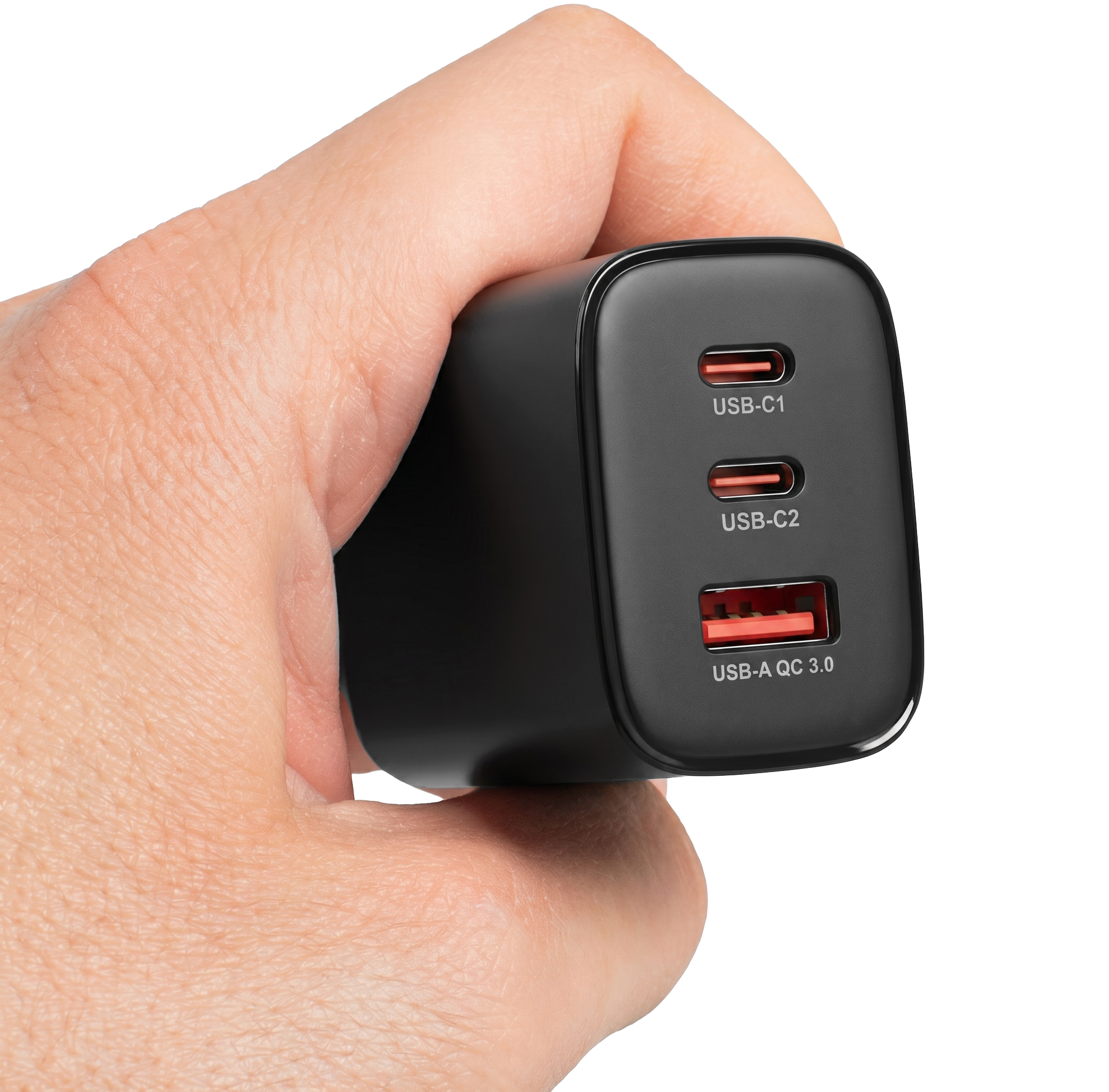 Egy kéz fekete, többportos töltőt tart két USB-C és egy USB-A porttal.
