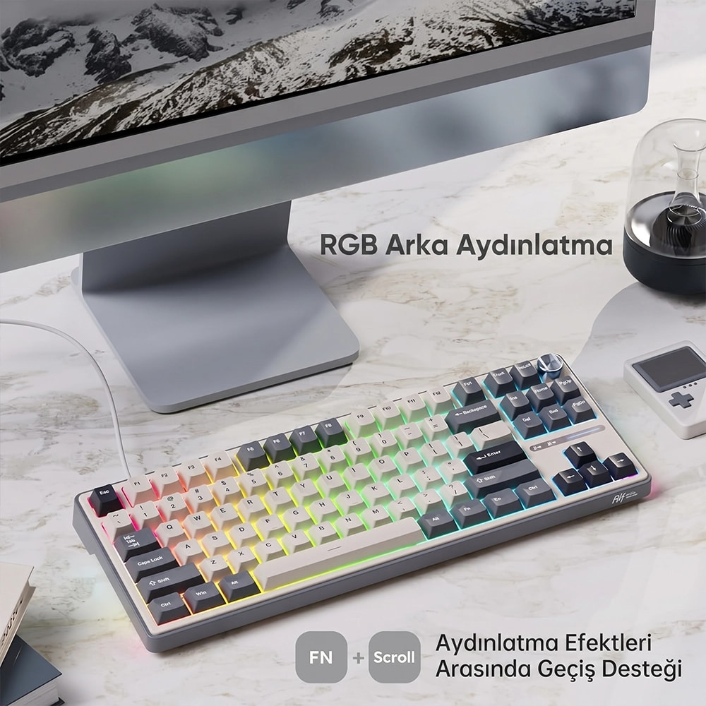 Klawiatura mechaniczna z podświetleniem RGB leży na marmurowym biurku przed monitorem.