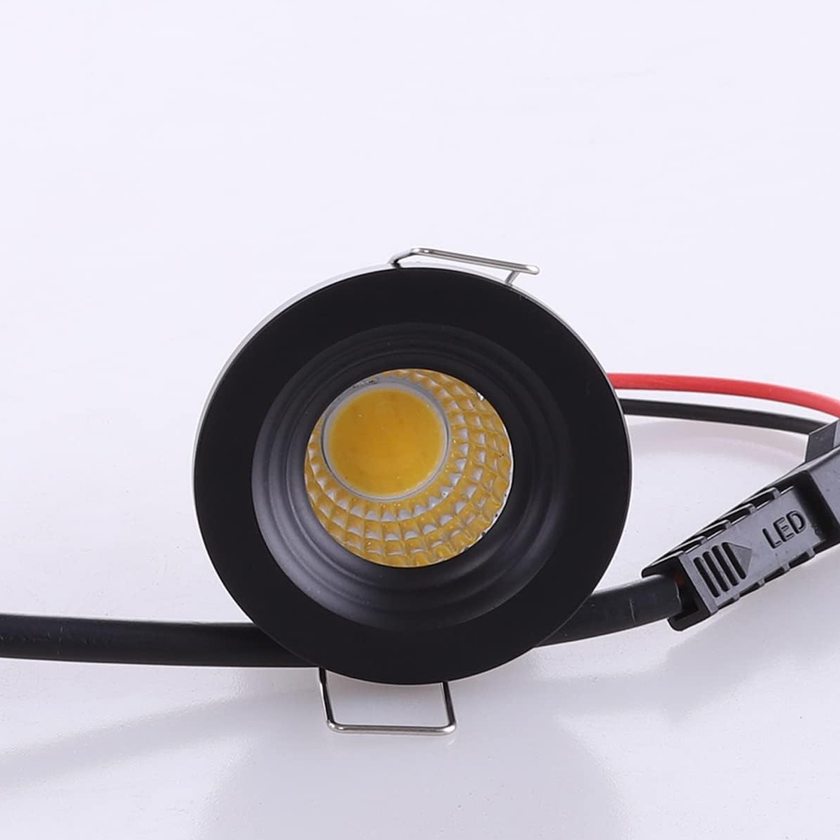 Runde schwarze LED-Einbauleuchte mit gelbem COB-Chip und angeschlossenen Kabeln vor weißem Hintergrund.