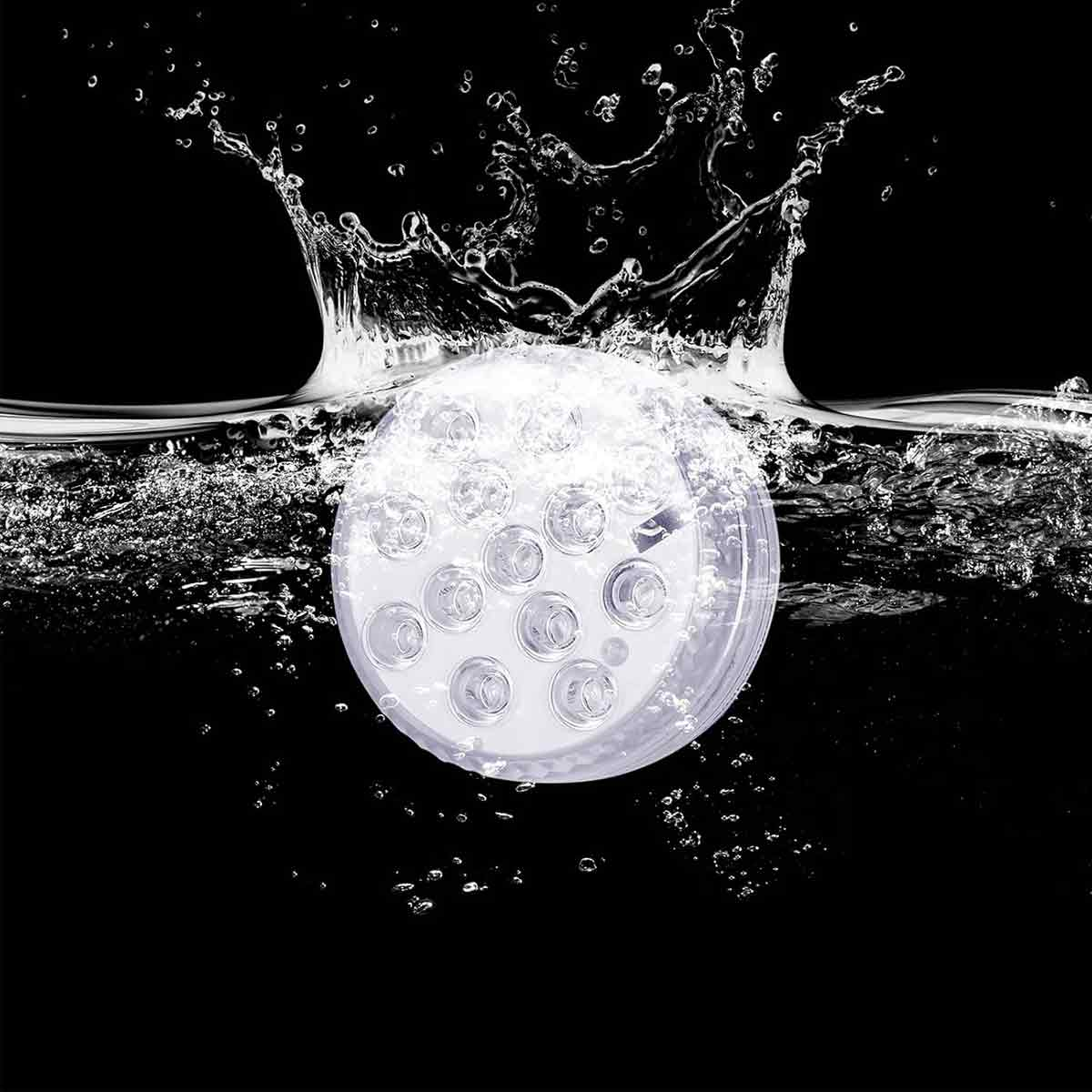 Runde LED-Leuchte, die in Wasser getaucht ist, mit spritzenden Wassertropfen vor schwarzem Hintergrund.