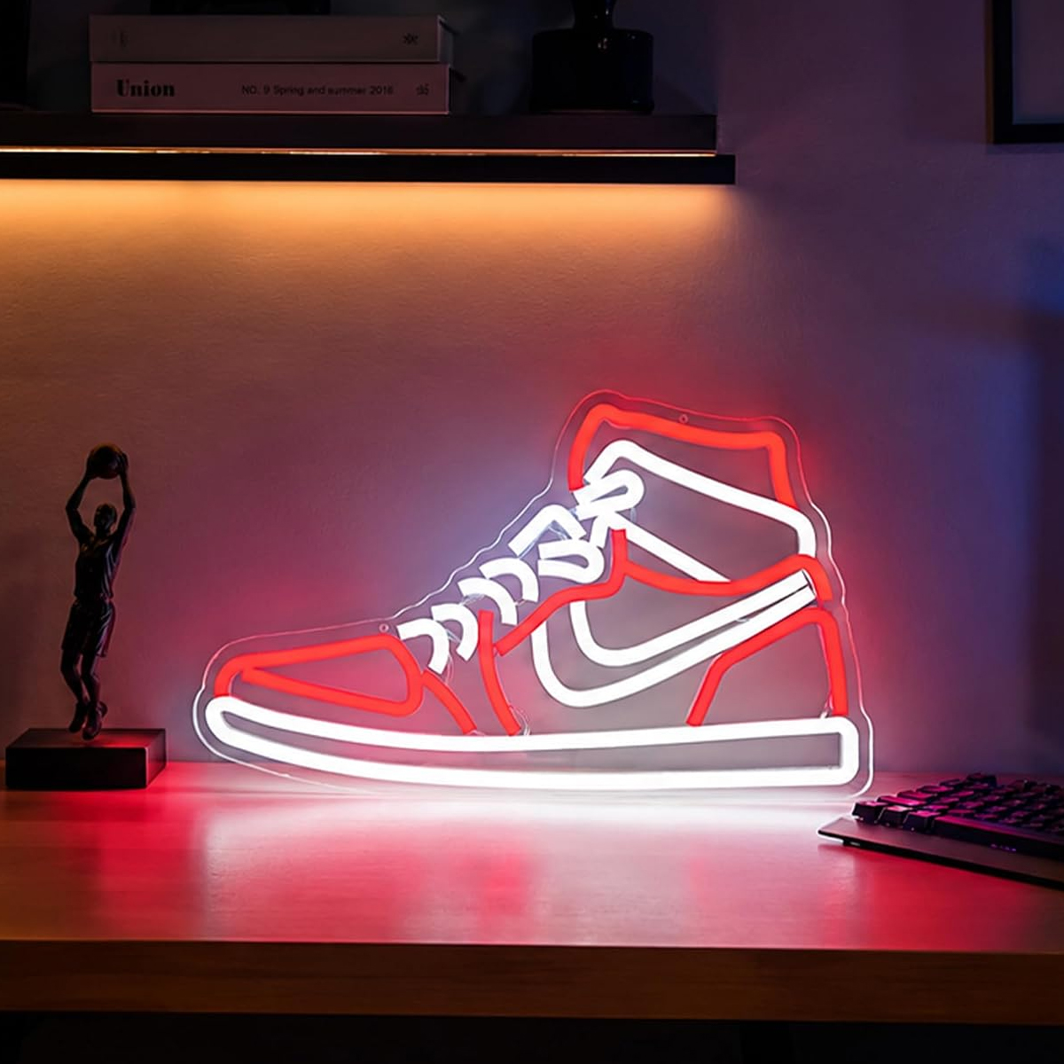 Eine rot-weiße Neonleuchte in Form eines High-Top-Sneakers steht auf einem Schreibtisch.