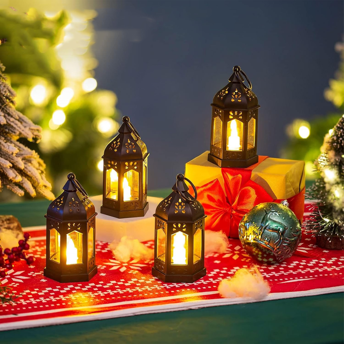 Vier schwarz beleuchtete Laternen auf einem rot-weißen Weihnachtsläufer mit Geschenken und Weihnachtsdeko im Hintergrund.