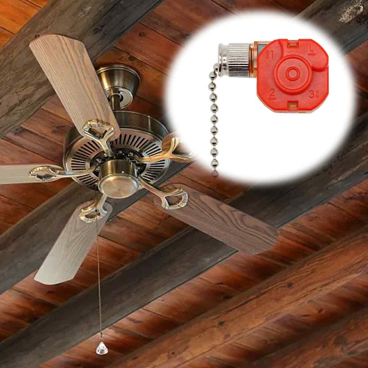 Ein Deckenventilator aus Holz mit einem eingefügten roten Kettenschalter auf einem Holzfaserhintergrund.
