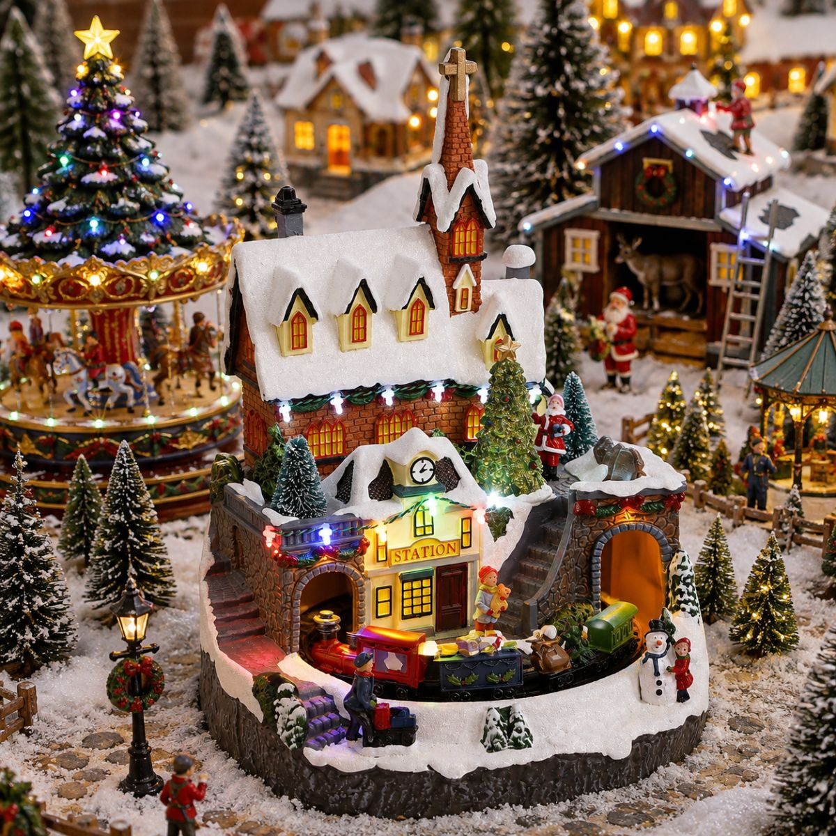 Verlicht kerstdorp-tafereel met station, trein, figuren en sneeuw.