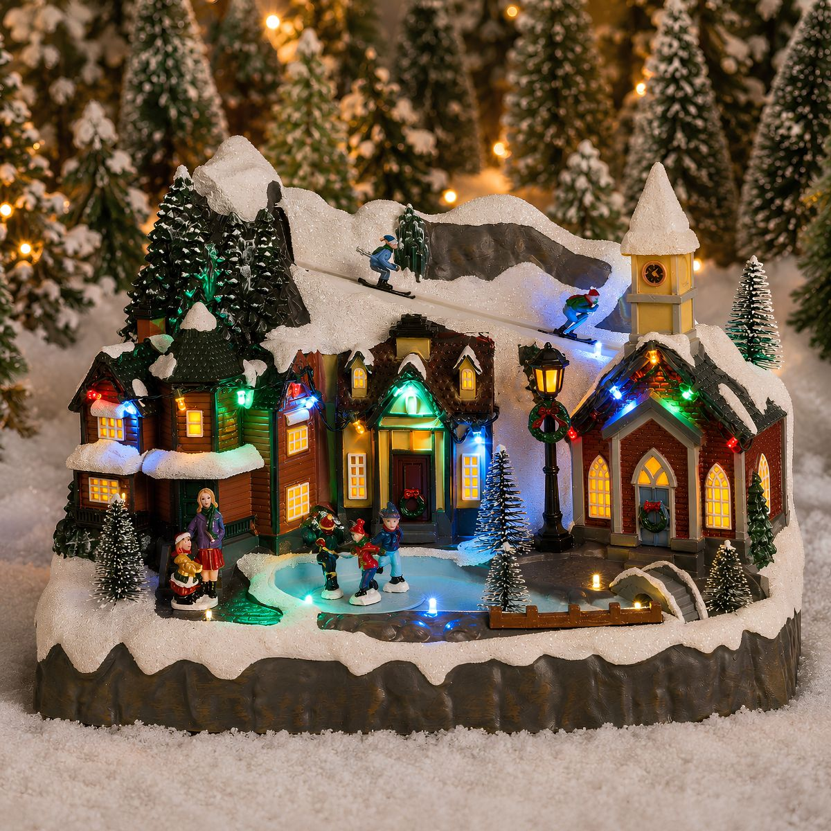 Verlicht kerstdorp met skiërs, schaatsers, besneeuwde huizen, een kerk en met sneeuw bedekte dennenbomen.