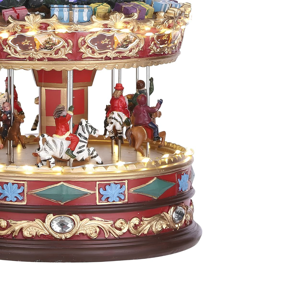 Een rood-gouden kerstcarrousel met kleine figuren op dieren en verlichting.