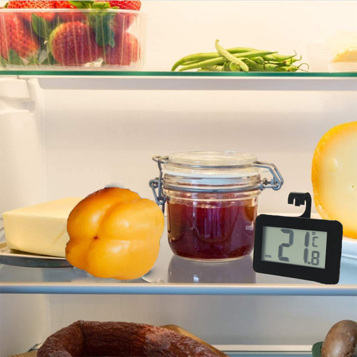 Kühlschrankregal mit frischen Erdbeeren, Bohnen, gelbem Paprika, Glas mit roter Marmelade und digitalem Thermometer.