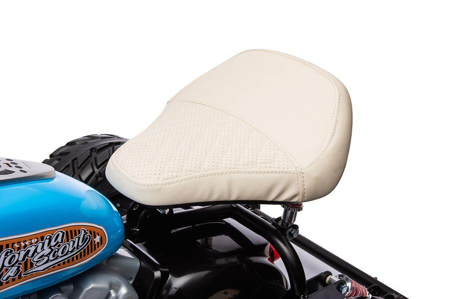 Ein weißer Ledersitz auf einem blauen Spielzeug-Motorrad mit Aufschrift und schwarzen Reifen.