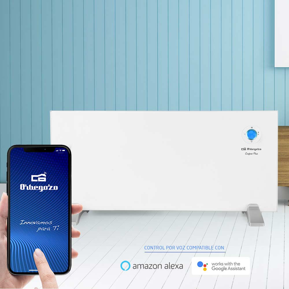 Un smartphone muestra una app frente a un calefactor blanco con control por voz para Alexa y Google Assistant.