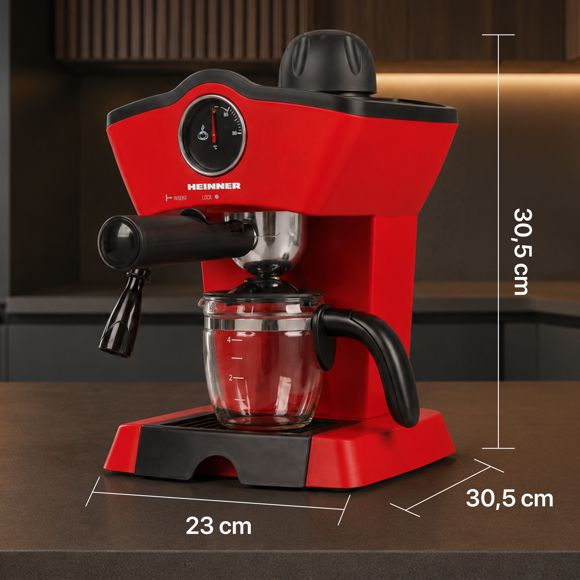 Machine à espresso rouge Heinner avec verseuse en verre, dimensions 30,5 x 23 x 30,5 cm, sur plan de travail.