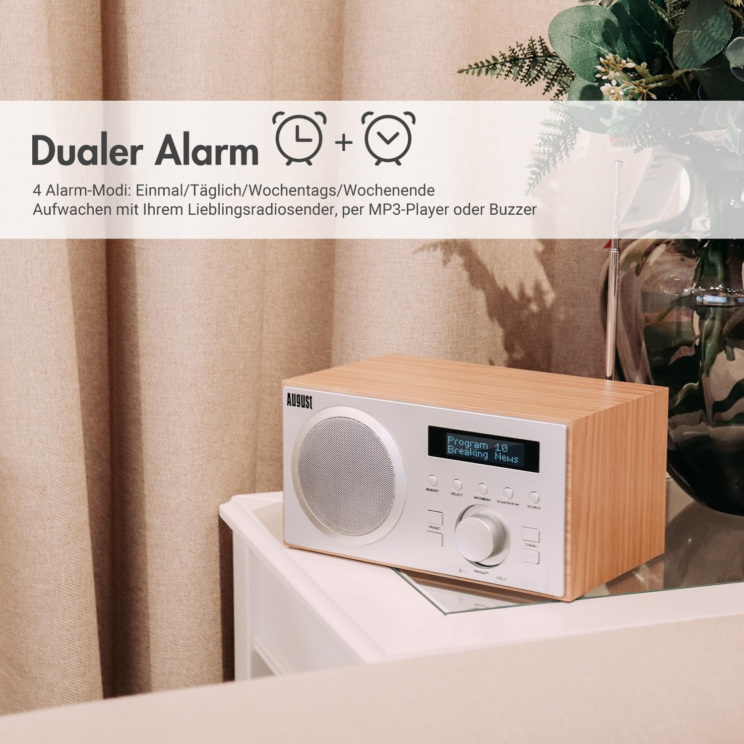 Radio in legno con pannello di controllo argento e display su un tavolo bianco davanti a tende.