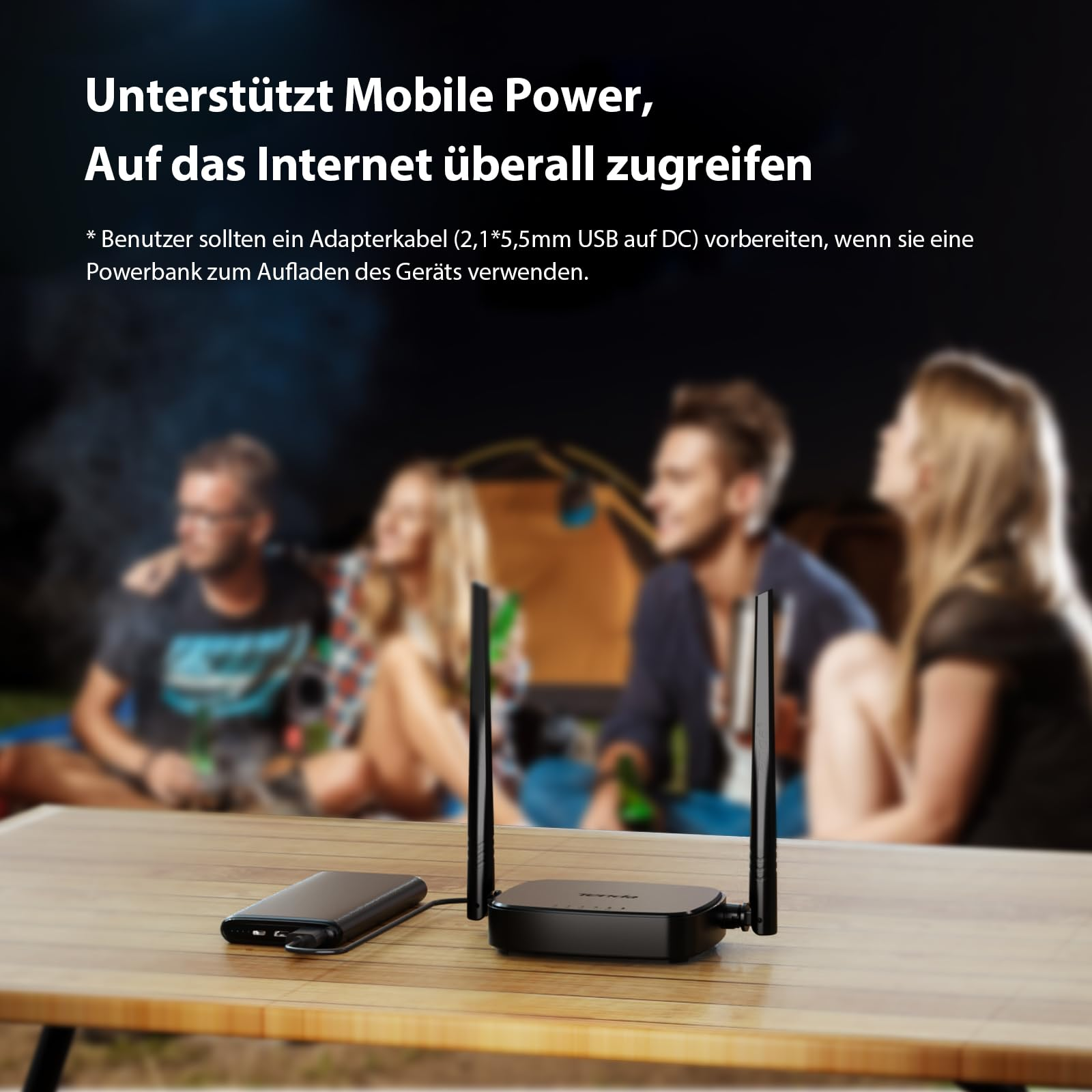 Un router Wi-Fi nero con due antenne è alimentato da un power bank su un tavolo di legno.