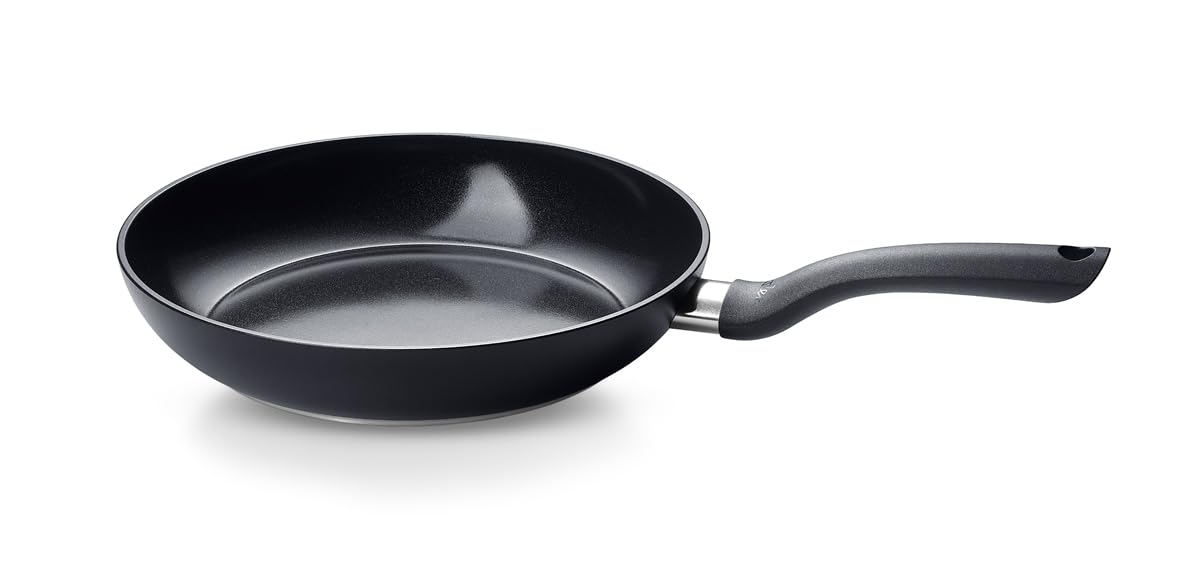 Une poêle à frire noire avec une poignée ergonomique sur fond blanc.