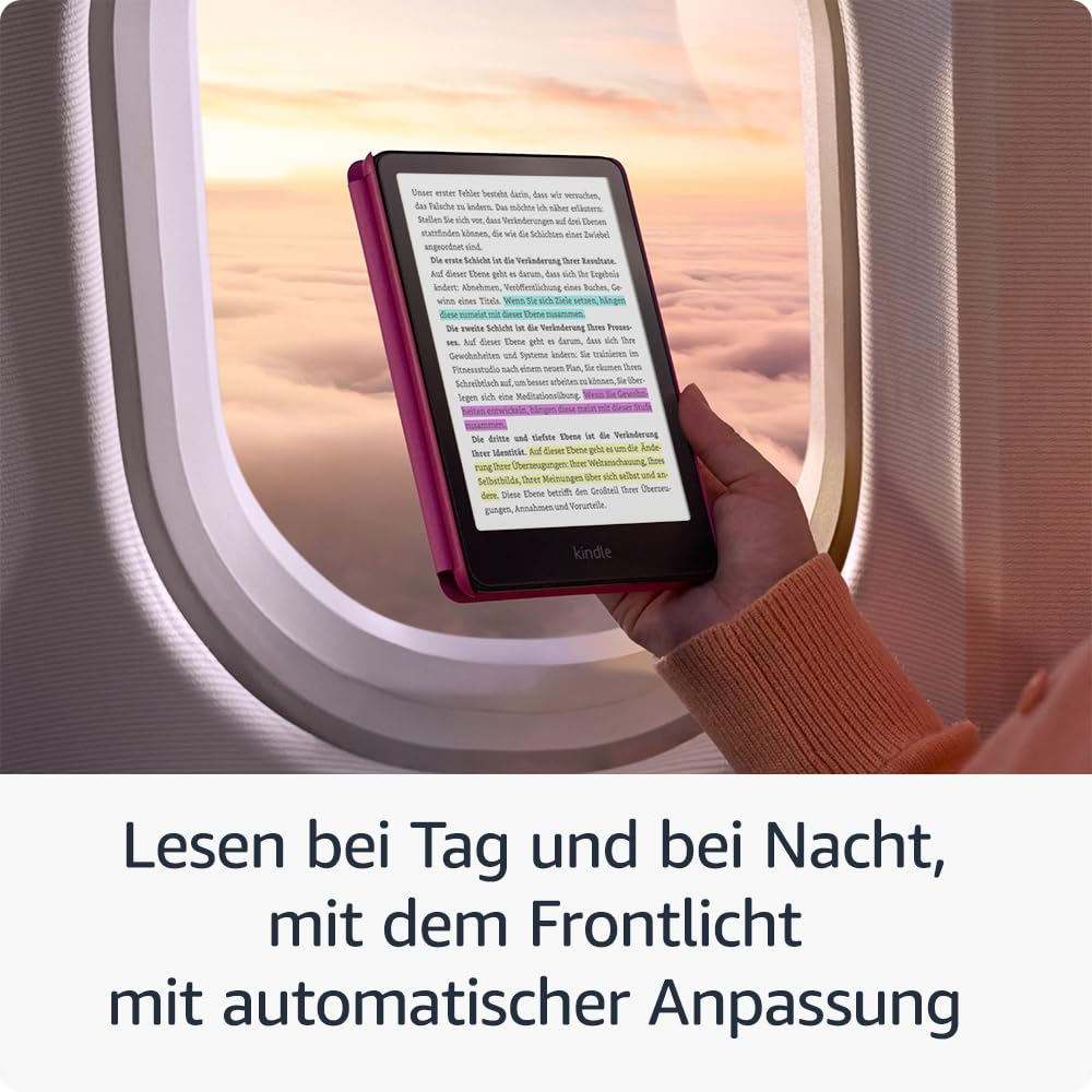 Une personne lit sur une liseuse Kindle dans un avion près d'une fenêtre montrant des nuages au coucher du soleil.