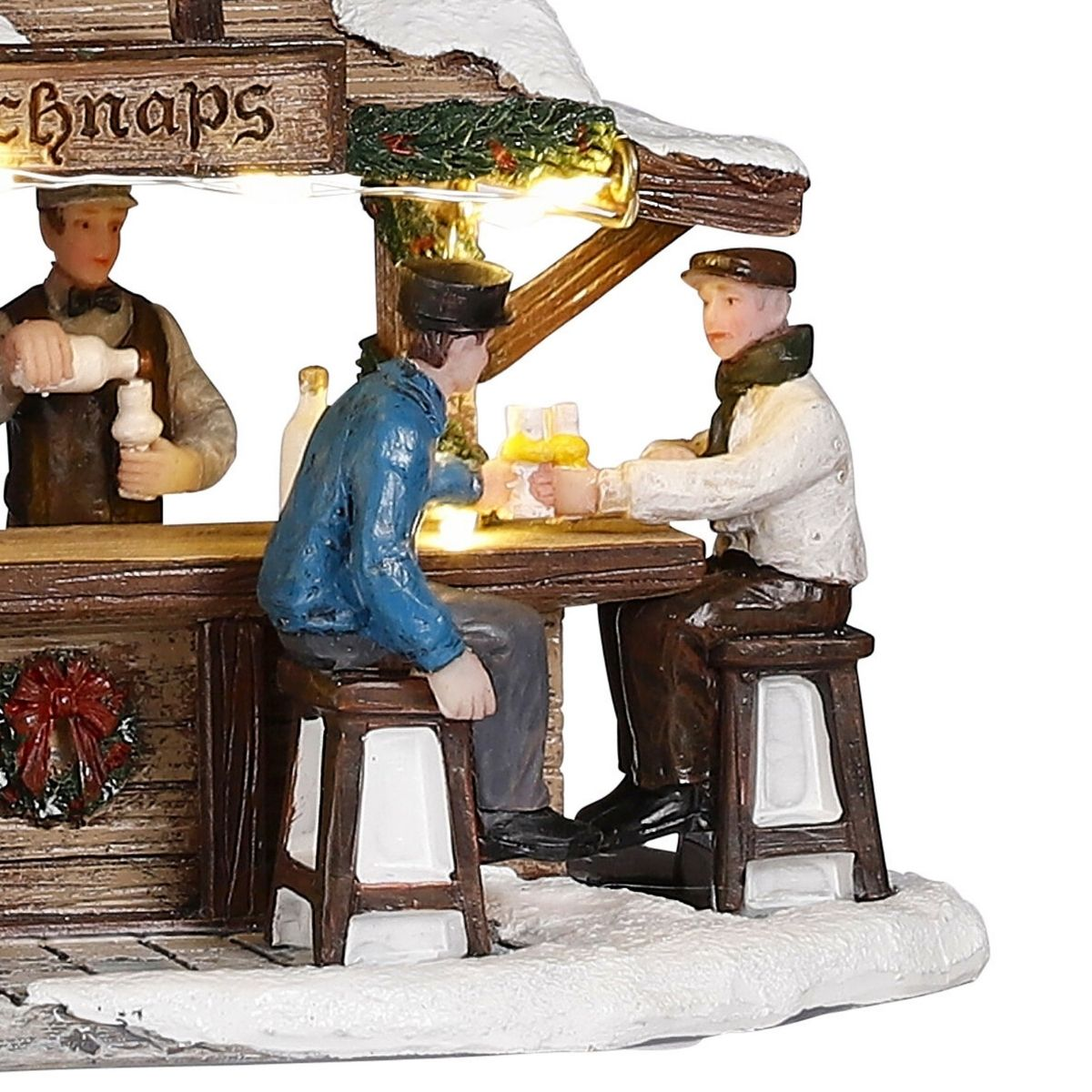 Bar de marché de Noël miniature avec un barman et deux hommes buvant de l'eau-de-vie.