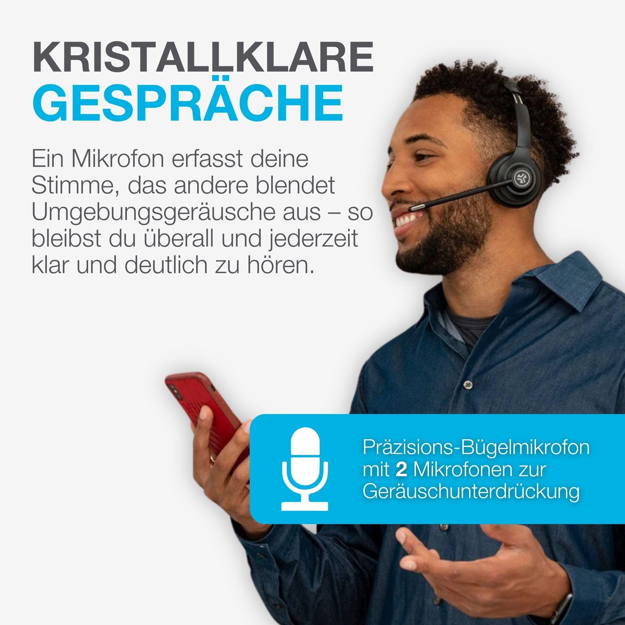 Ein Mann mit Headset und Smartphone lächelt und telefoniert vor weißem Hintergrund.