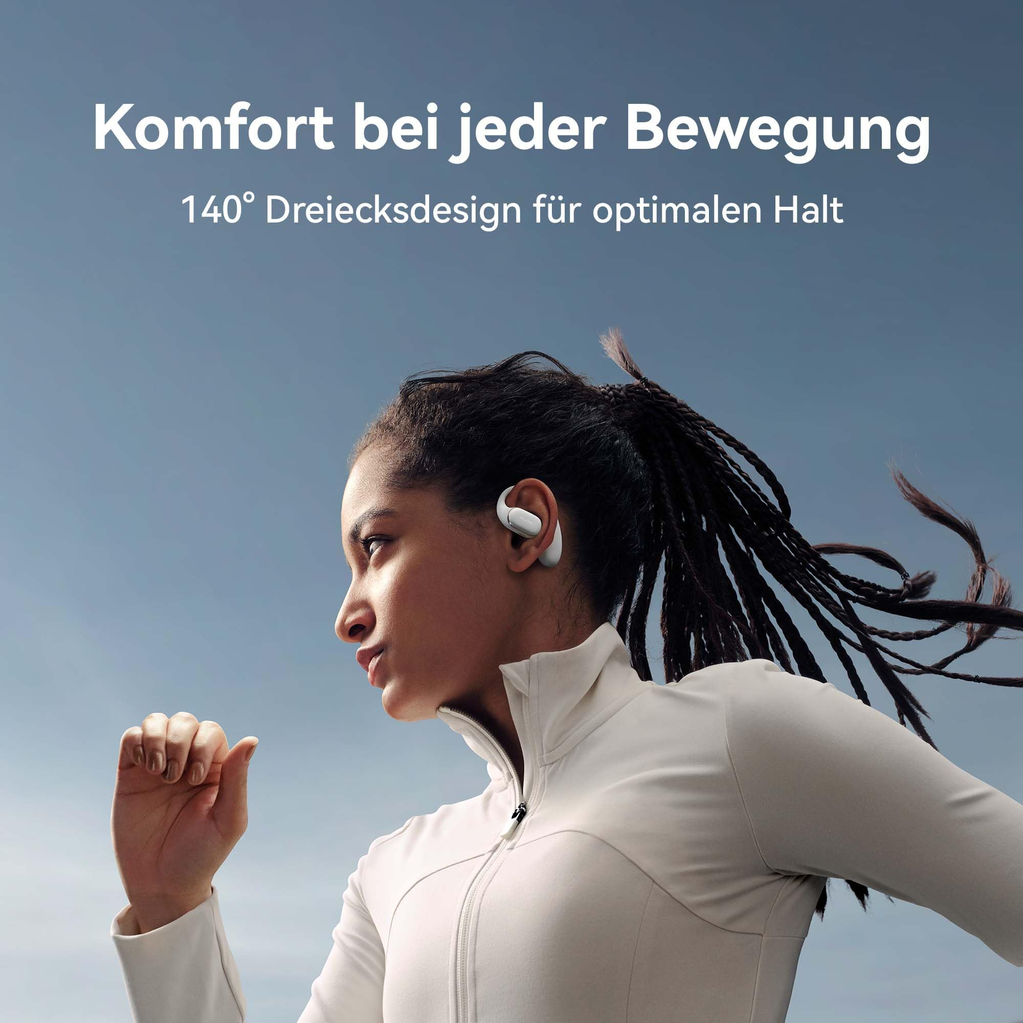 Eine Frau mit langen geflochtenen Haaren läuft, trägt weiße Sportkleidung und weiße Ohrhörer vor blauem Himmel.