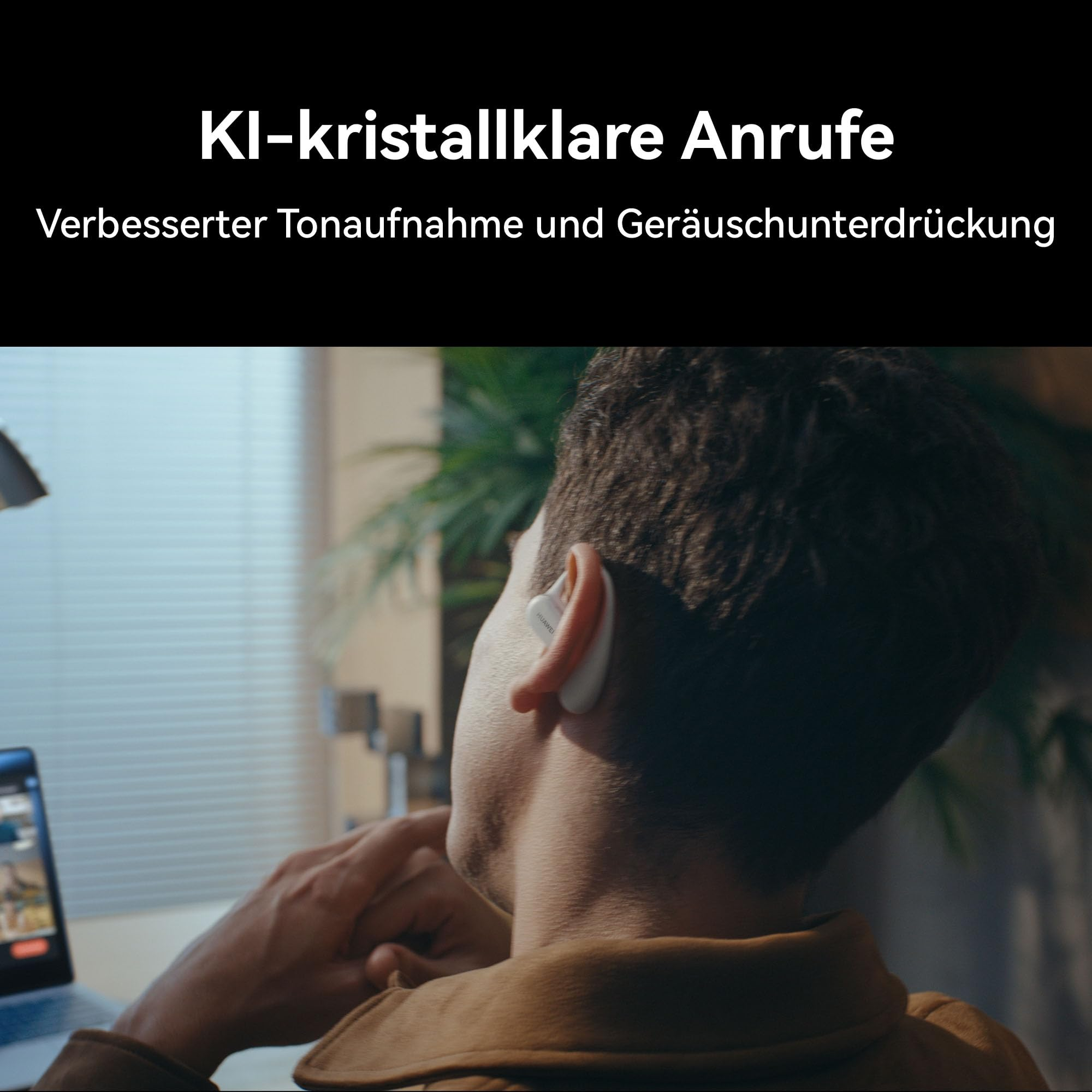 Ein Mann mit weißem In-Ear-Kopfhörer sitzt vor einem Laptop in einem Raum mit Pflanzen und Jalousien.