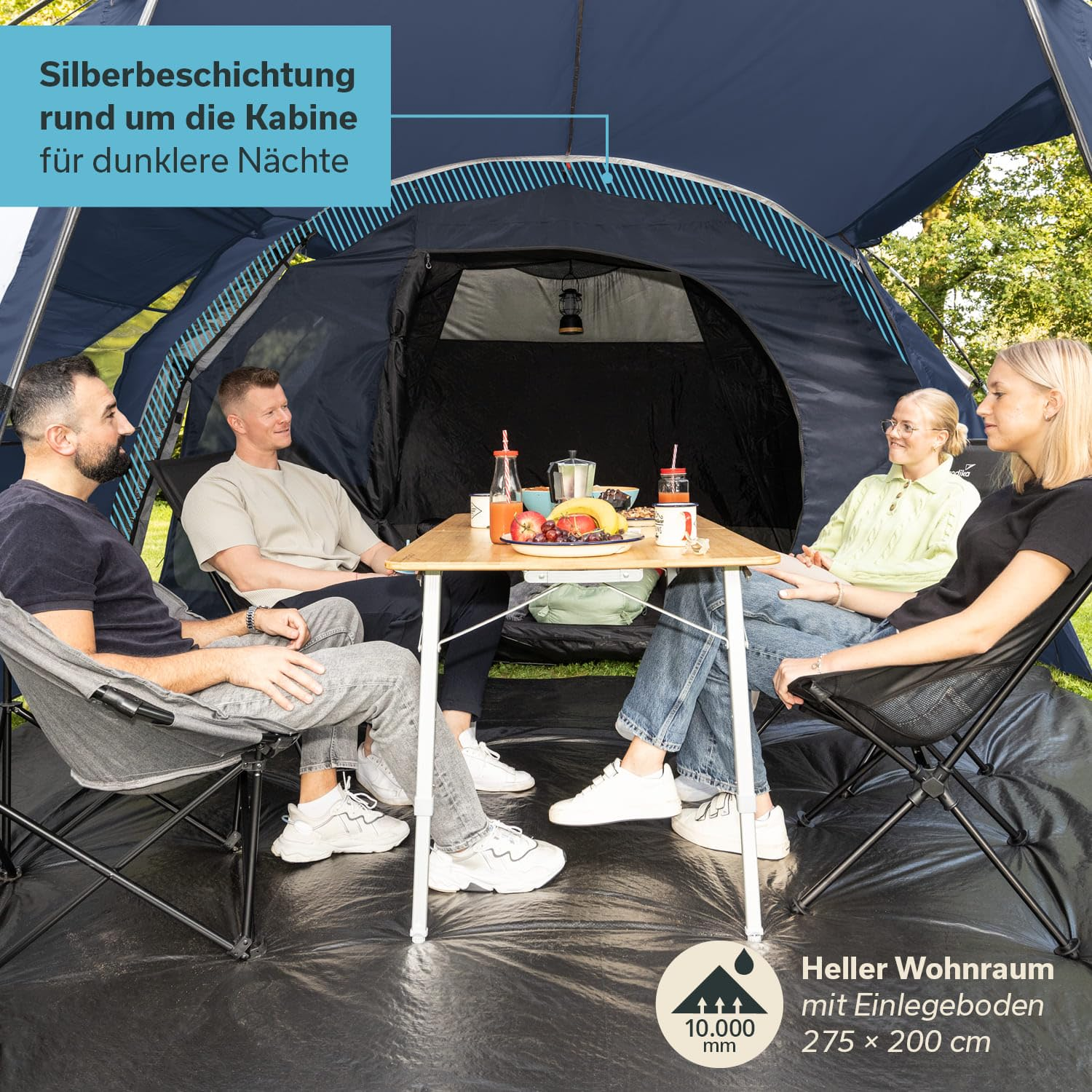 Quatre personnes sont assises sur des chaises de camping autour d'une table dans une grande tente bleue. Des fruits et des boissons sont posés sur la table.