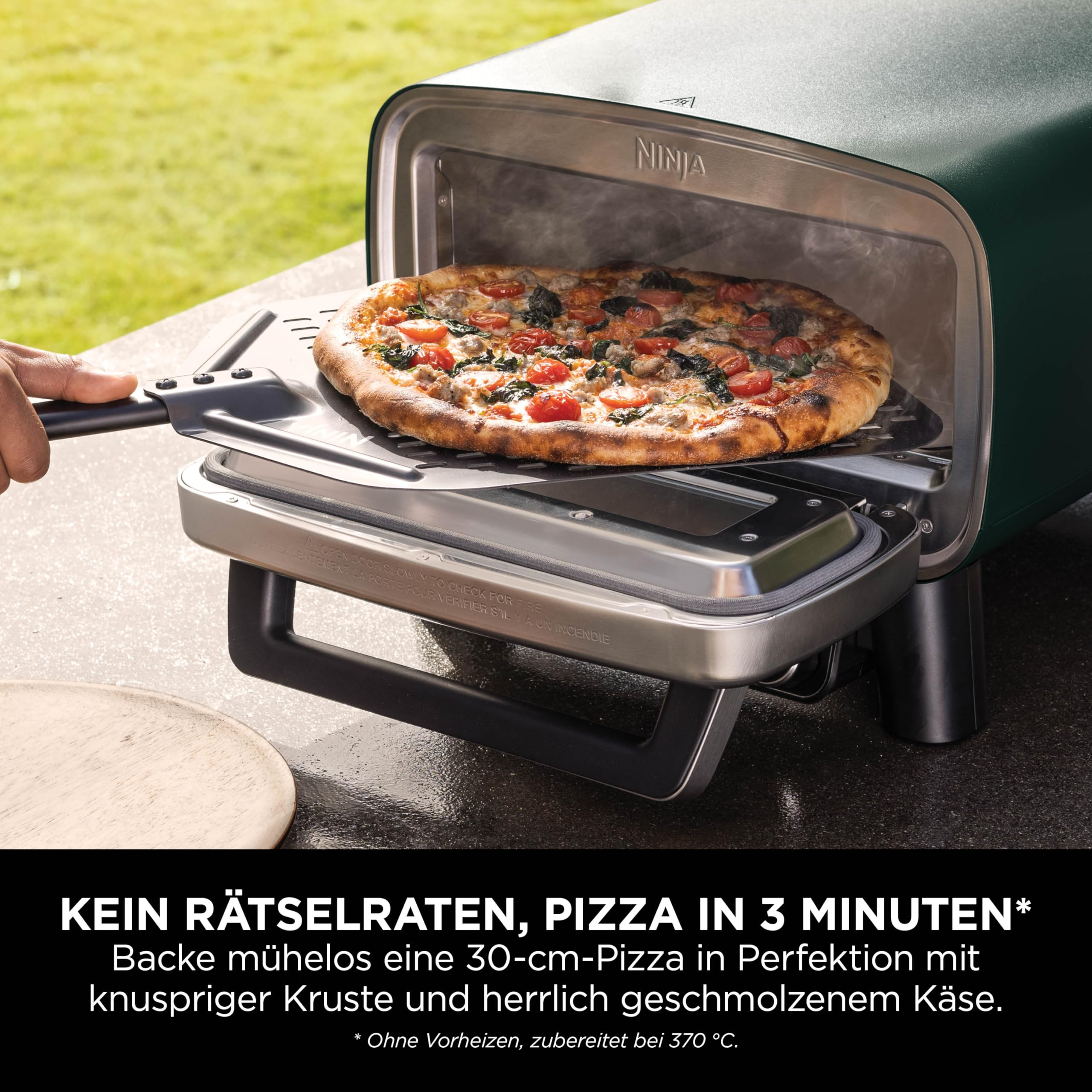 Une personne sortant une pizza fraîchement cuite d'un four vert Ninja avec une pelle.