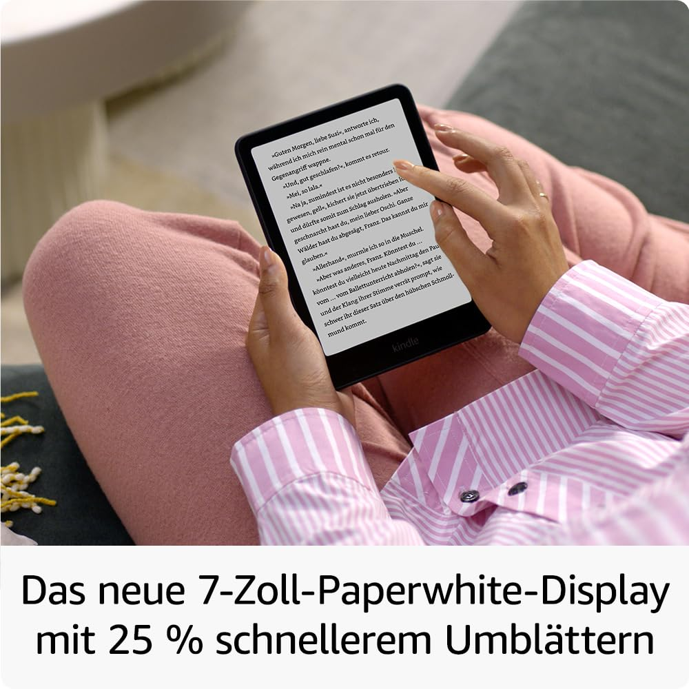 Une personne assise avec un pantalon rose tient une liseuse noire affichant du texte en allemand.