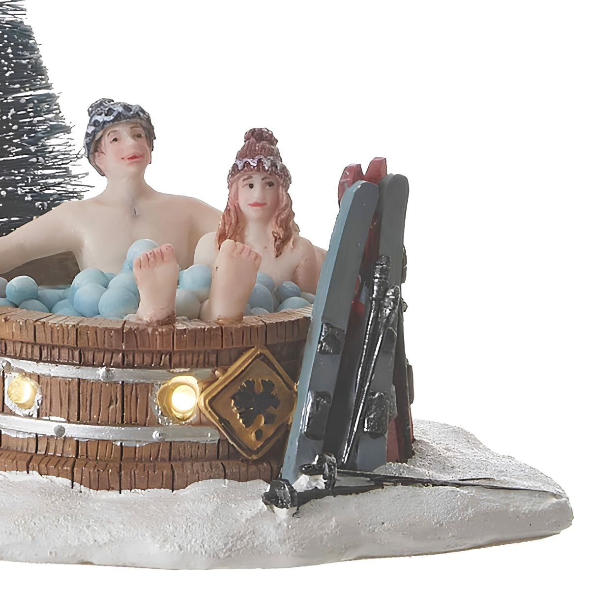 Figurines miniatures dans un bain nordique avec de la mousse et des skis.