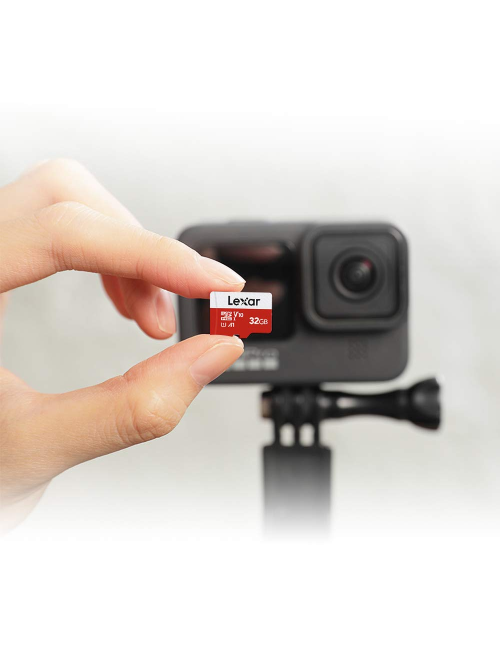 Une main tient une carte microSD Lexar de 32 Go devant une caméra d'action.