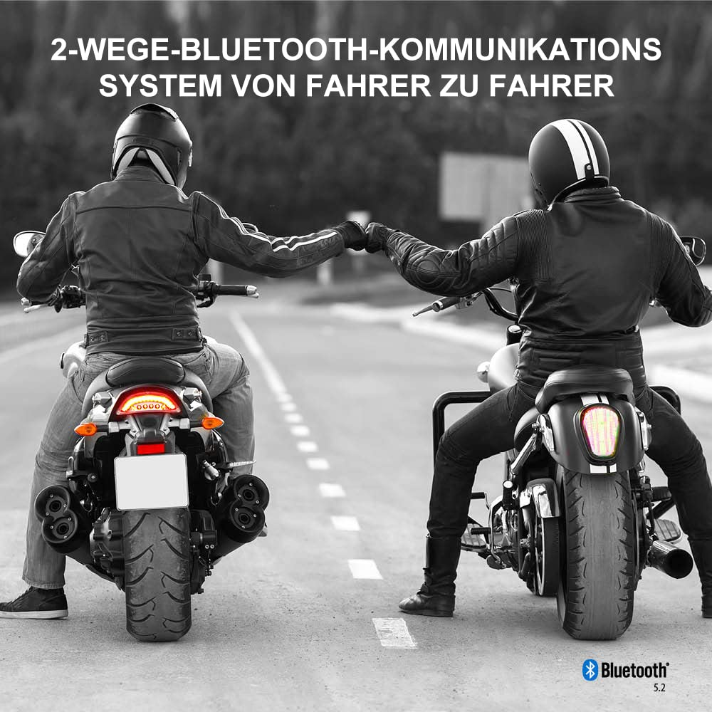 Zwei Motorradfahrer sitzen auf ihren Maschinen und stoßen auf einer Straße mit den Fäusten zusammen.