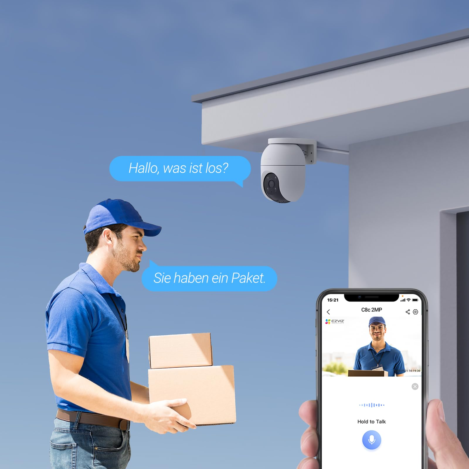 Un corriere tiene dei pacchi davanti a una casa mentre una telecamera di sicurezza lo riprende e lo mostra su uno smartphone.
