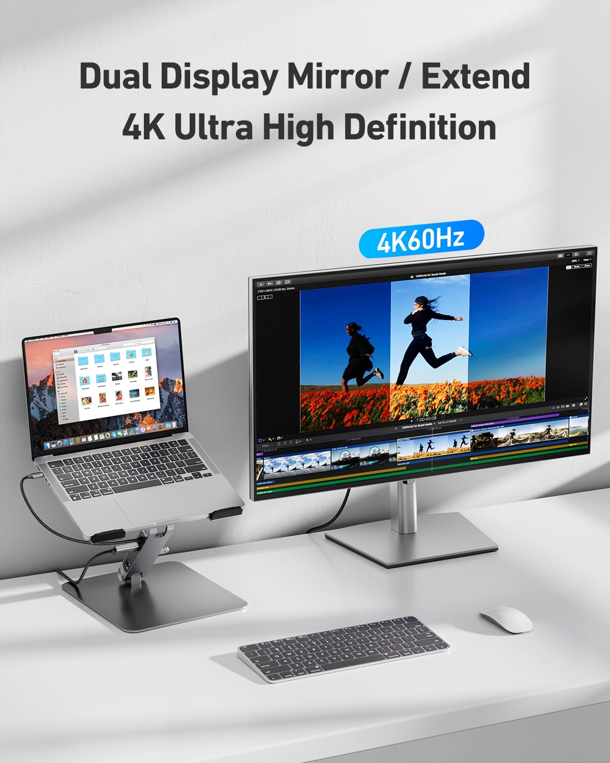 Un laptop su supporto è collegato a un grande monitor 4K, con tastiera e mouse su una scrivania bianca.