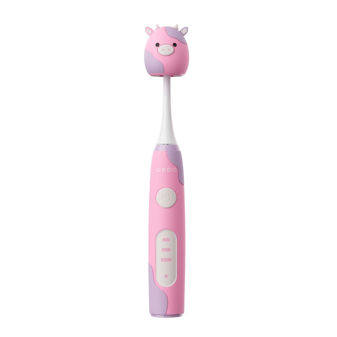 Eine rosa-lila elektrische Zahnbürste im Kuh-Design mit passender Reisekappe auf weißem Hintergrund.