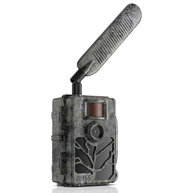 Une caméra de chasse camouflage grise avec capteur infrarouge, objectif et longue antenne.