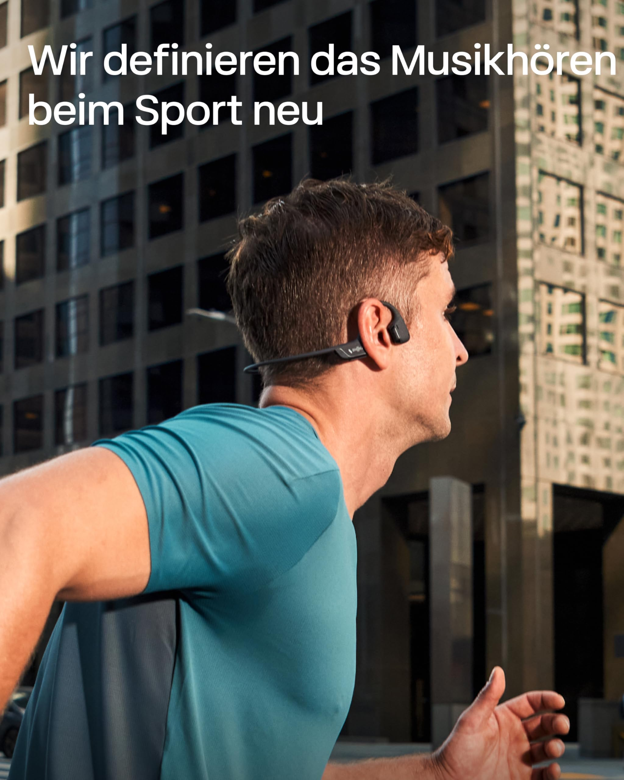 Ein Mann in blauer Sportkleidung joggt vor einer großen Glasfassade eines Stadtgebäudes.