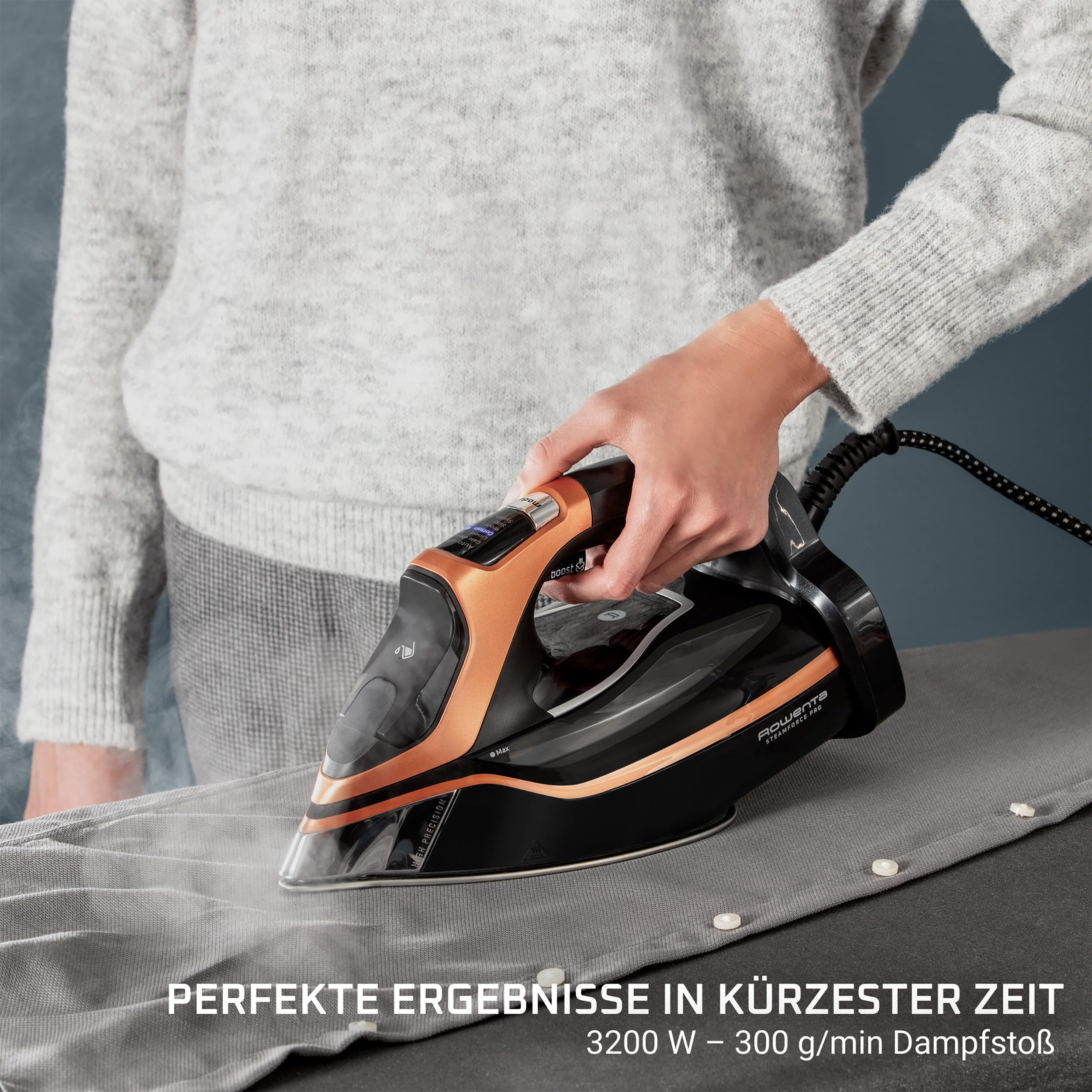 Une personne repasse du tissu gris avec un fer à vapeur noir et cuivré.